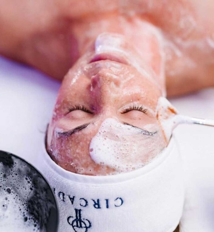 Reinigungsschaum wird mit dem Pinsel im Gesicht verteilt – Double Cleansing im 50-Minuten-Facial in Wien